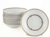 Plusieurs assiettes blanches à bord doré sont empilées les unes sur les autres