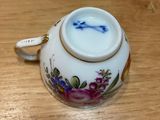a small cup with a handle on a wooden table