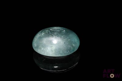 une image représentant une boule de jade verte posée sur une surface noire