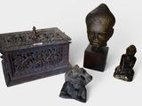 three statues of buddhas and a box on a table