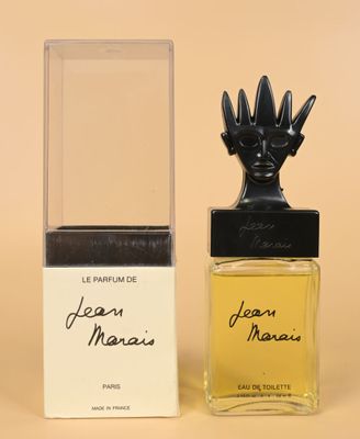 a bottle of jean manus perfume next to a box