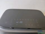 a black clock sitting on top of a black printer