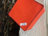 a red box on a white wall with a sticker on it