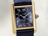 une image représentant une montre noire et dorée dont le cadran est orné de chiffres romains