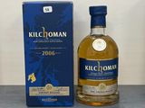 La bouteille de Kilchomann se trouve à côté de la boîte, sur la table.