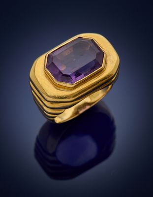 a gold ring with an amethorate stone in the center