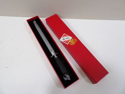 une boîte rouge contenant un stylo noir