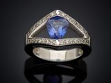a blue sapphire and diamond ring on a black surface