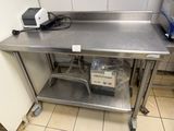 stainless steel work table in a commercial kitchen with a heater on top of it