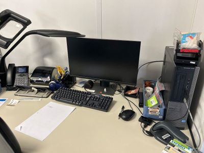 un bureau sur lequel se trouvent un ordinateur, un clavier, une souris et d'autres objets