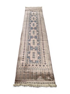 un tapis de passage beige et bleu à franges sur fond blanc