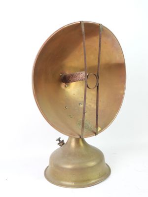 a small brass object on a metal stand on a white surface