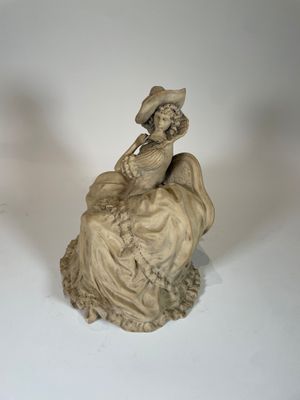 une statue représentant une femme assise sur un rocher
