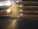 a gold fork and a silver spoon on a table