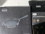 une boîte de gants de cuisine pour four à pizza à côté d'une paire de gants