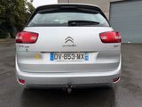 the rear end of a silver car parked in a parking lot