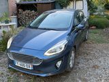 a small blue car parked in front of a house