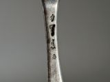a silver spoon with a flower on it on a table
