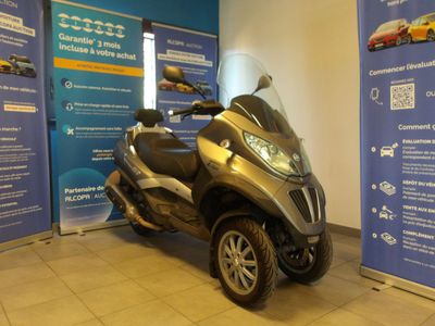 un scooter garé devant une banderole bleue