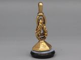 a gold bell with a black base on a gray surface