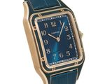 the watch is blue with a gold case and a blue dial