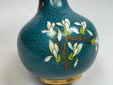 a blue vase with white flowers on it sitting on a table