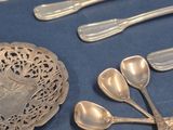 a lot of silver spoons and silverware on a table