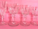 quatre verres à vin sont alignés sur un plateau rose