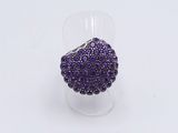a purple beaded ring sitting on top of a clear cup