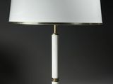 une lampe de table blanche avec un pied doré et un abat-jour blanc