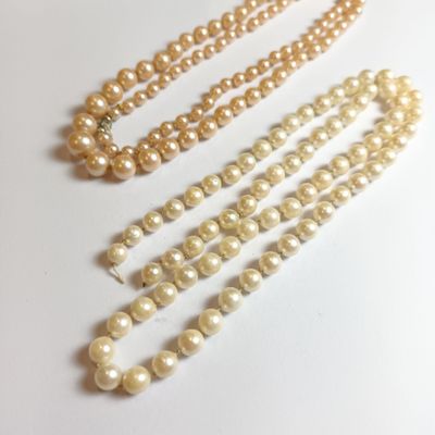 trois rangées de perles sont disposées en ligne sur une surface blanche