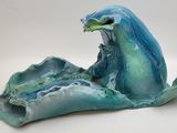 une sculpture bleue et verte représentant une vague jaillissant de l'océan