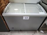 a freezer that is sitting on the floor next to a brick wall