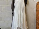 a white dress hanging on a clothes rack in a room