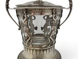 an antique silver plated ice bucket with two lions on it