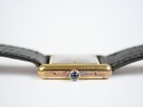 a close up of a watch on a white surface