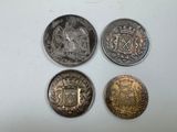four different types of coins sitting on top of a white surface