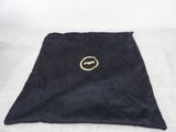 black towel with a gold logo on it sitting on a white surface