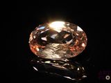 an orange diamond on a black surface with a black background