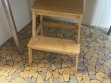 a wooden step stool under a table in a kitchen