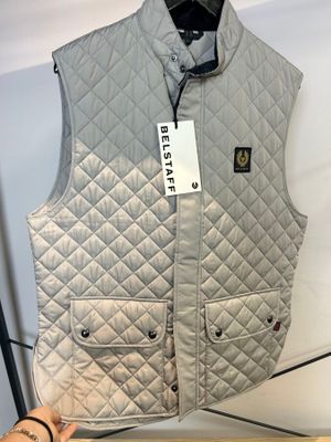 gilet matelassé gris exposé dans un magasin, muni d'une étiquette de prix