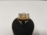 un gros plan d'une bague en or posée sur un présentoir noir
