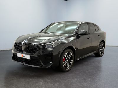 une voiture noire garée dans un showroom devant un mur blanc