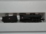 un petit train miniature exposé sur une étagère blanche
