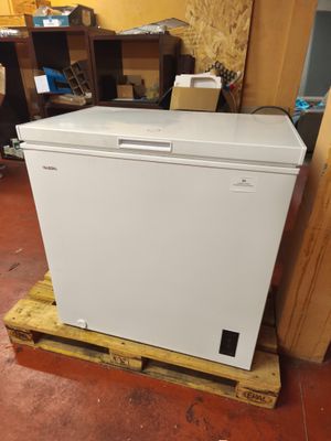un réfrigérateur blanc posé sur une palette dans une pièce