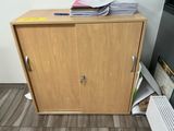 a wooden cabinet with a bunch of files on top of it