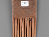 an old wooden comb with a tag on it sitting on a table