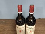 two bottles of wine sitting on top of a wooden table