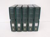 six livres verts sont alignés sur une surface blanche