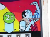 a picture of a pinball machine with a man holding a drink